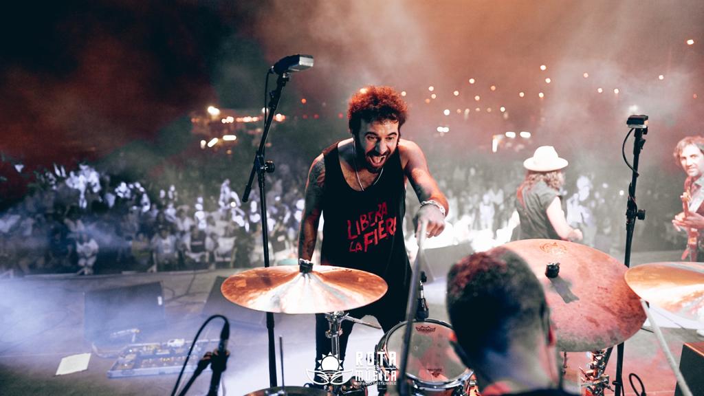 El Canijo sonríe al batería que toca junto a él.